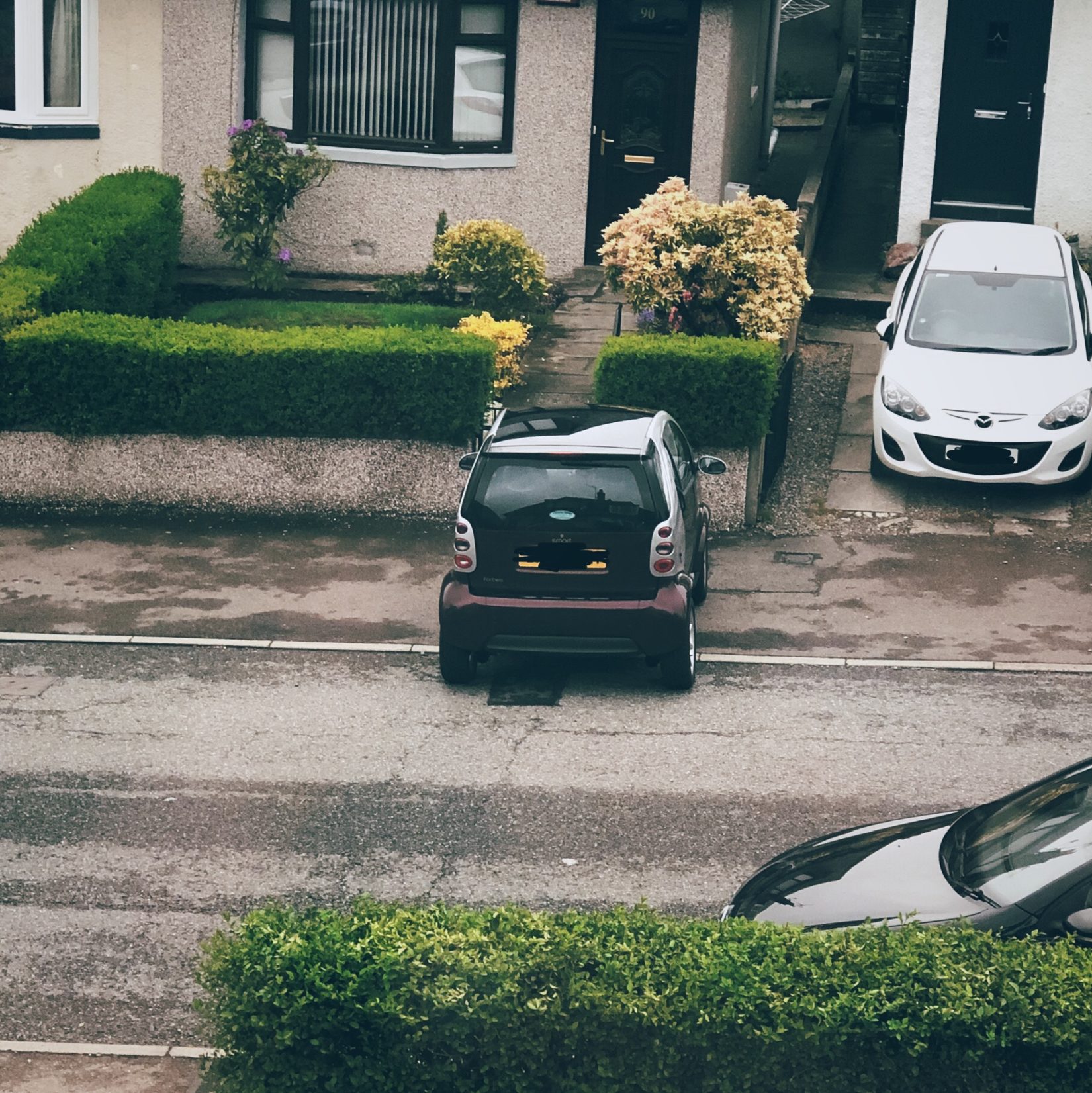Tiny car parked in a way to block the pavement